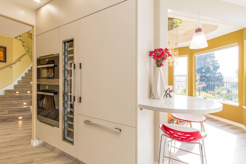 Kitchen island with built-in appliances and built-in breakfast high-top table.