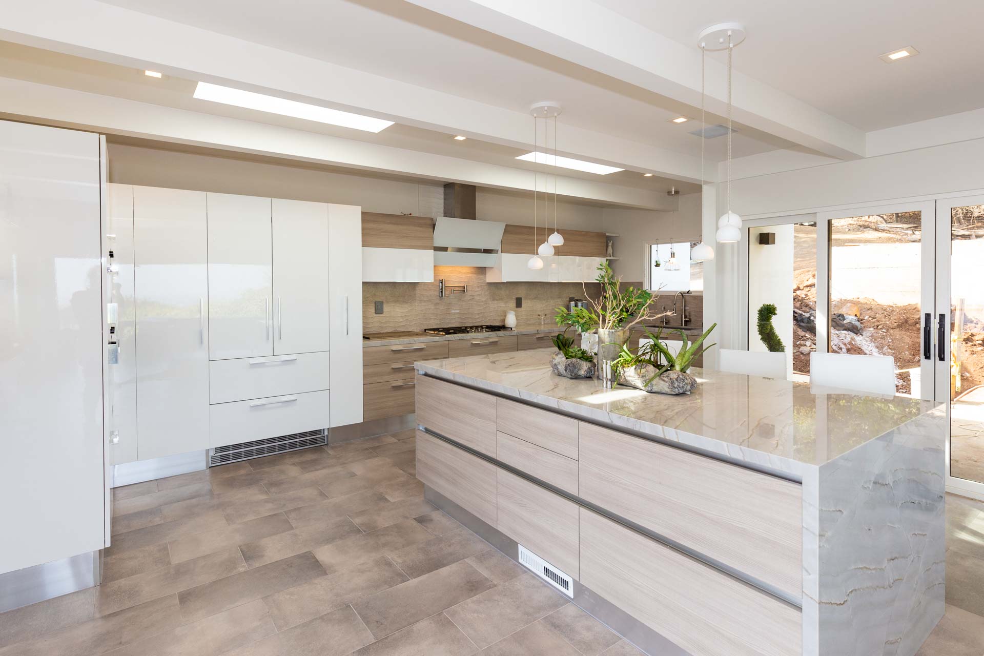 Beige and white kitchen with impressive greenery on island