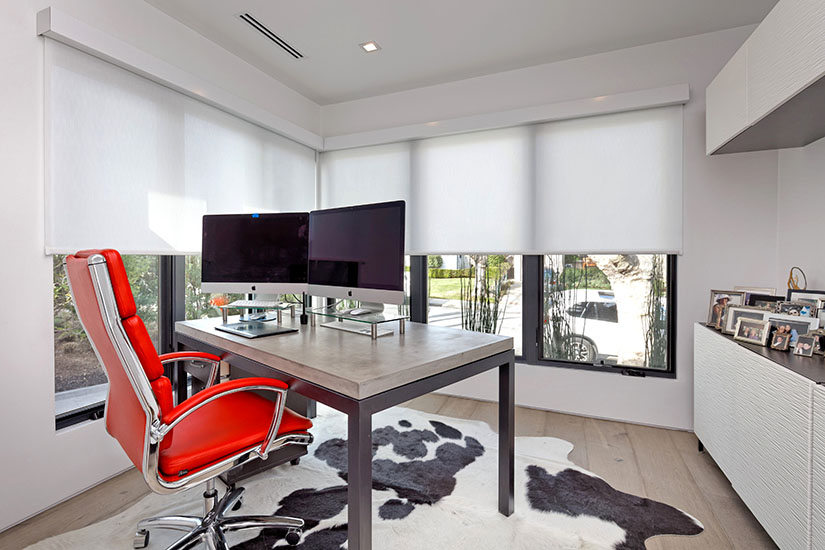 Home office with large windows and red chair reflecting modern house design