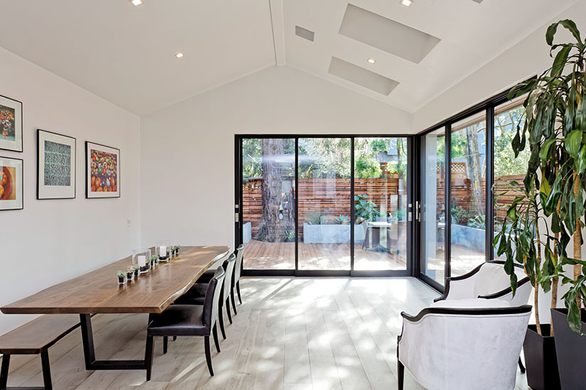 Bright dining room with lots of natural light and a long custom wood table