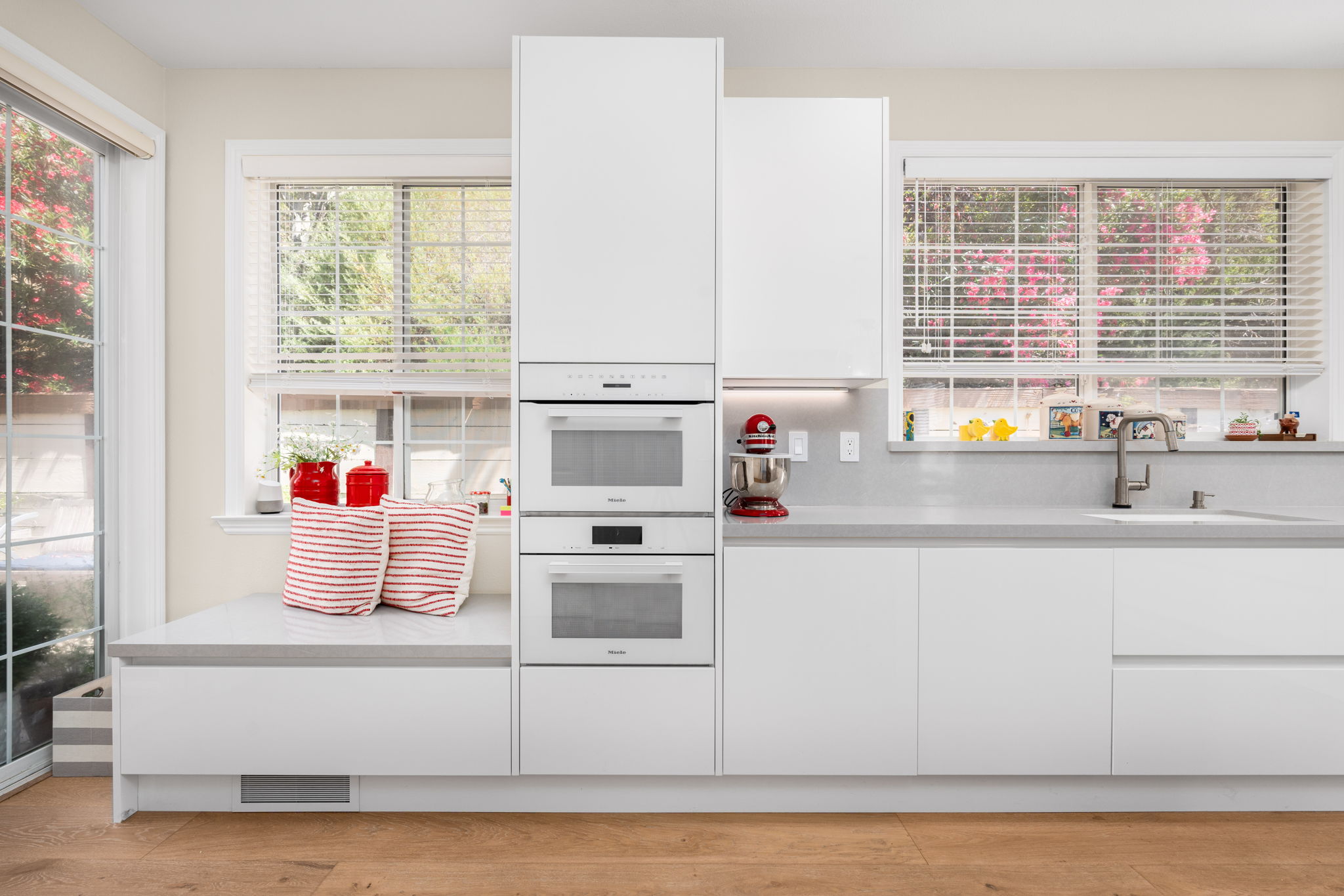 White modern Italian kitchen with a white marble waterfall countertop island.