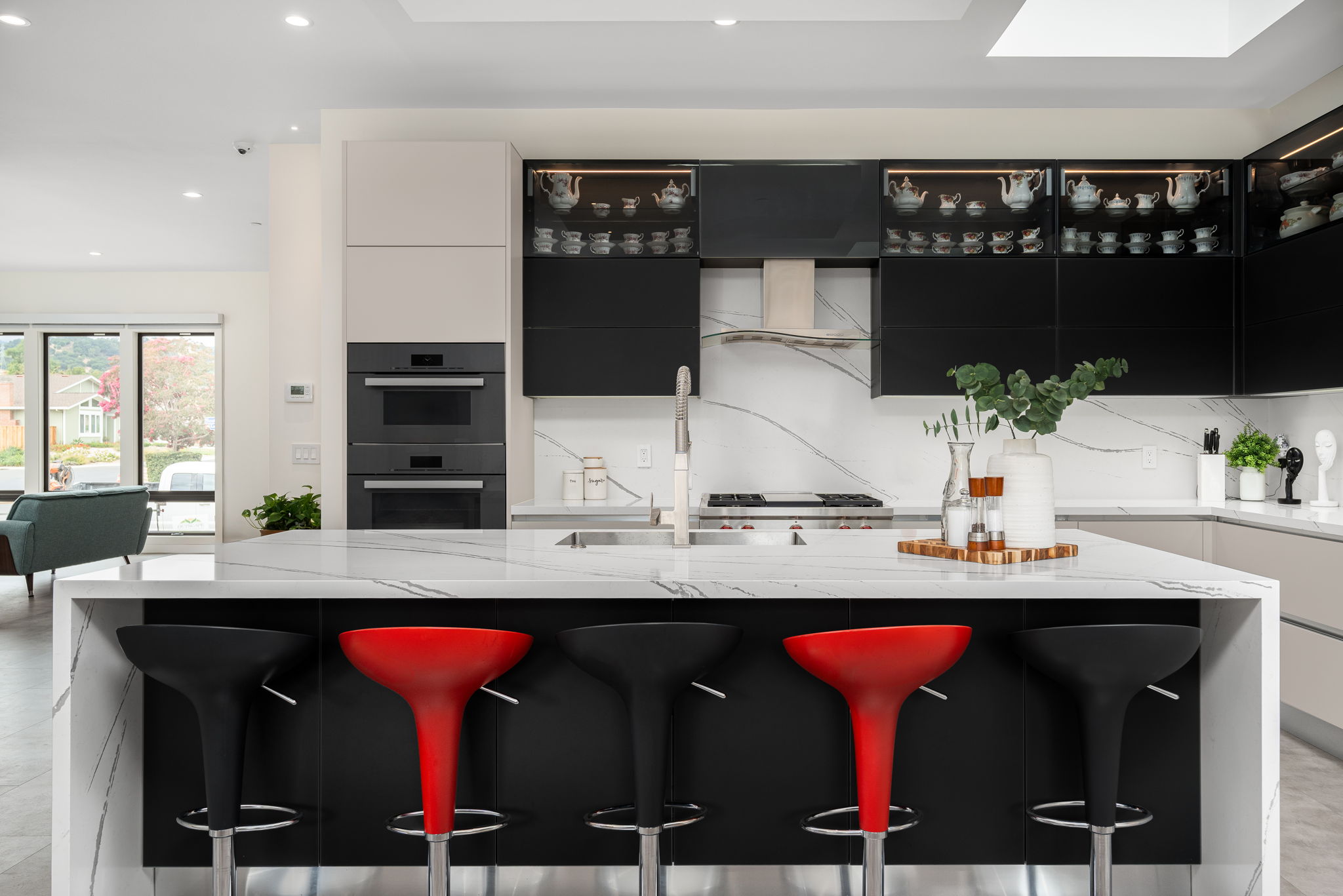 Modern Italian kitchen with PET and glass cabinets and a marble waterfall island.