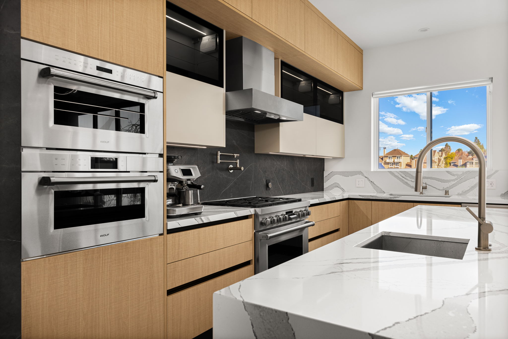 Custom European kitchen with integrated appliances and a mix of wood and glass cabinetry from one of our projects.