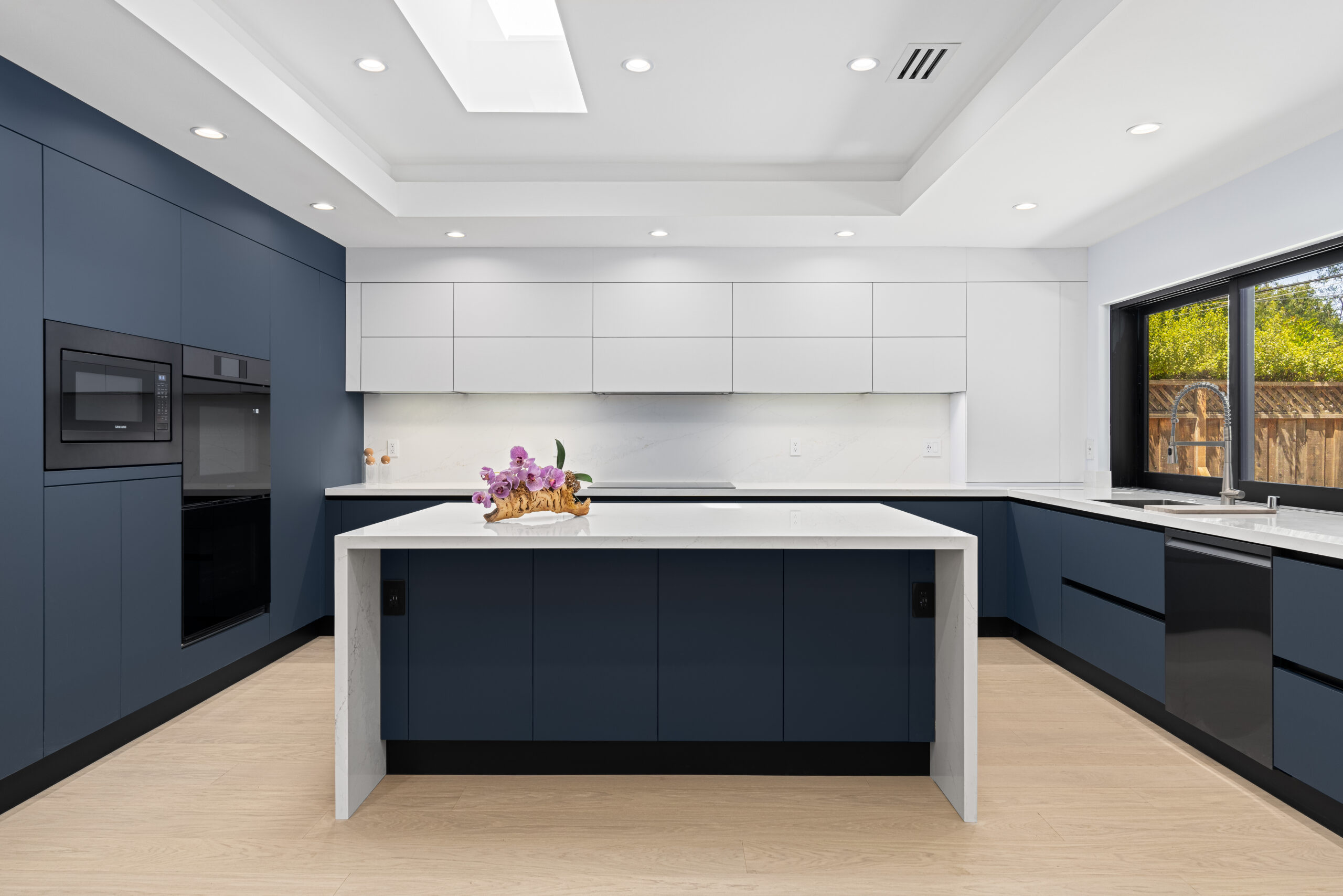 Modern European kitchen with frameless, handleless cabinets, integrated appliances, and minimalist design.