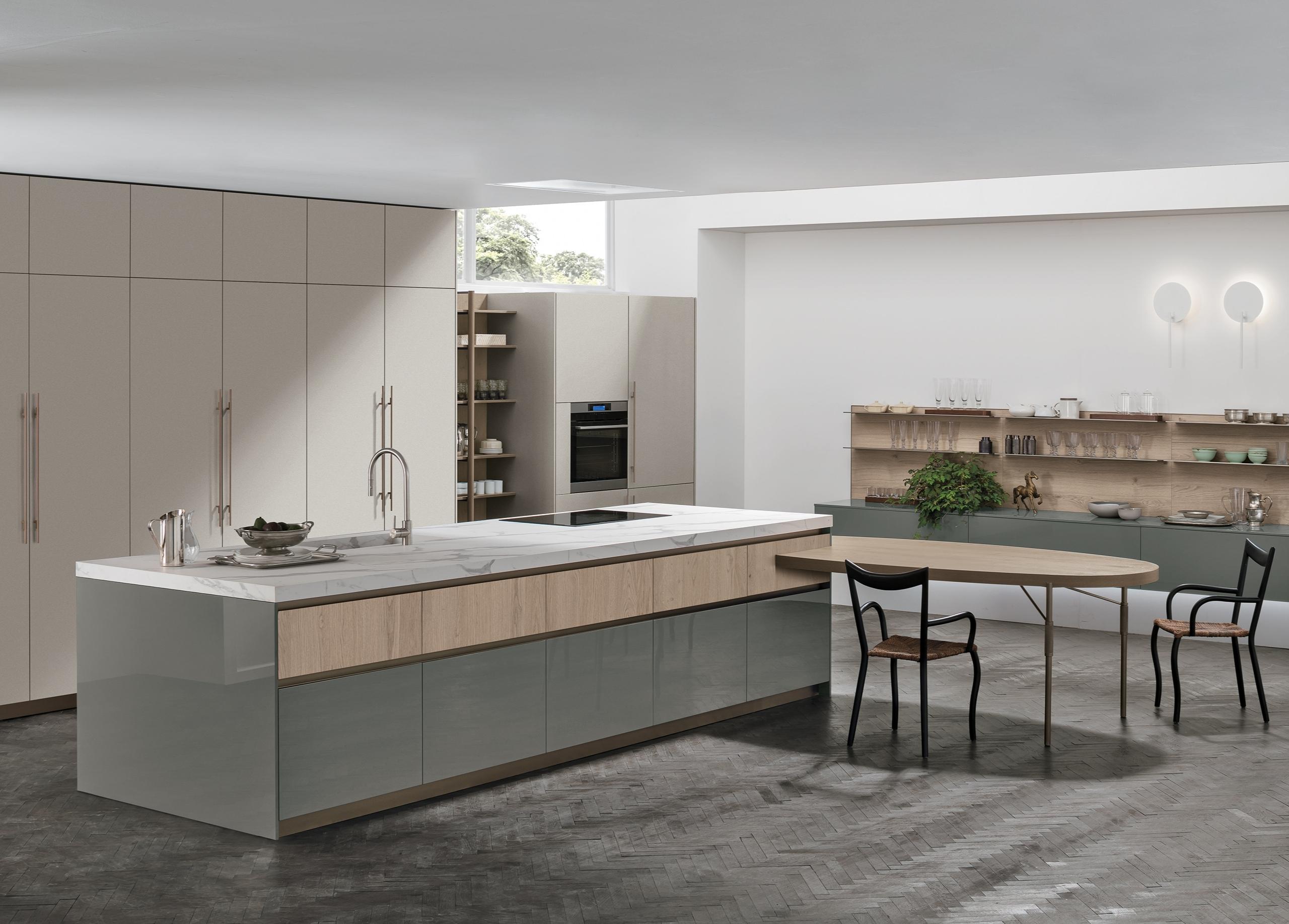Modern Italian kitchen with beige tall cabinets, sage green glossy base units, and a marble-topped island by Stosa Cucine.
