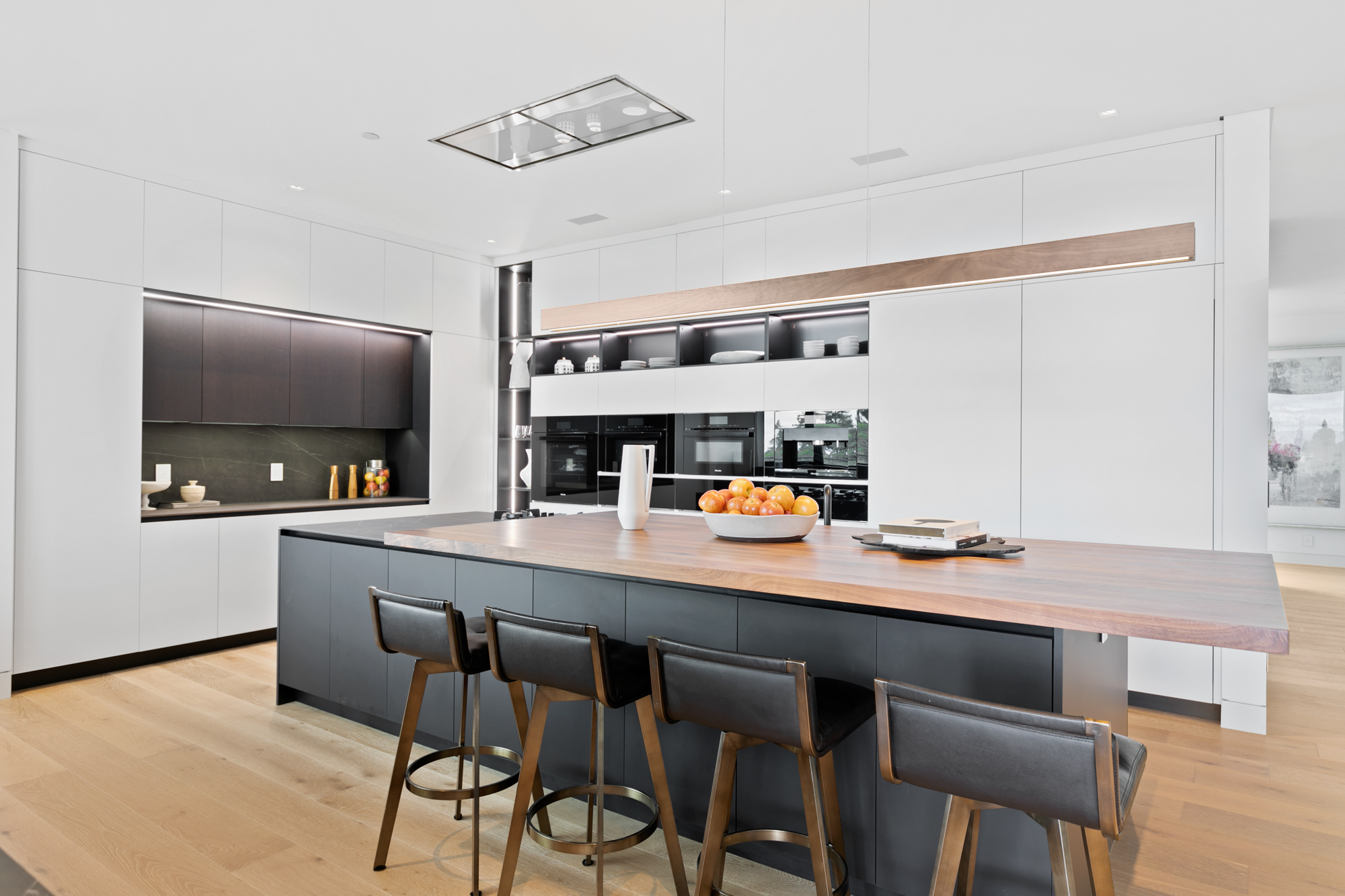 Task-zoned modern European kitchen with a large central island, integrated appliances, and layered cabinetry designed for cooking, prep, and entertaining in a Hillsborough home.