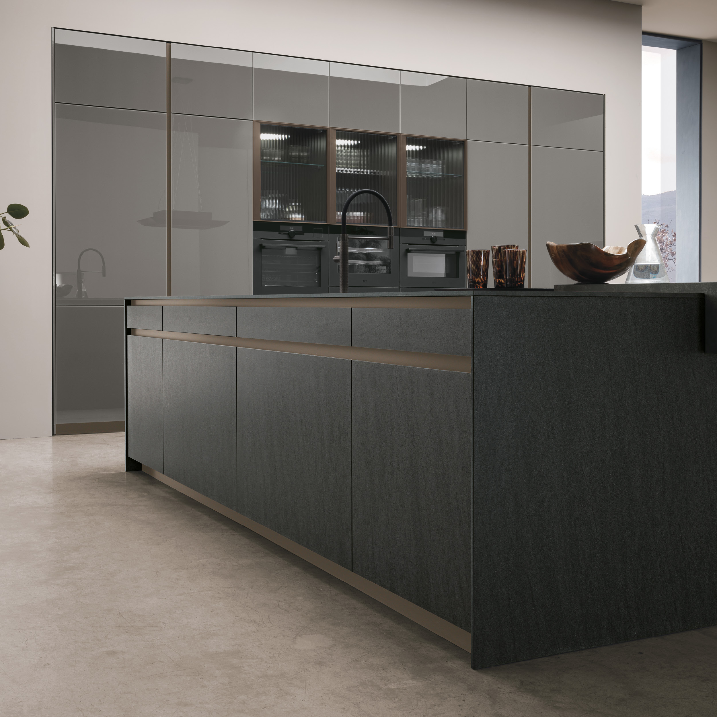 Modern Italian kitchen with glossy grey glass cabinets, a dark textured island, bronze trim and integrated appliances.